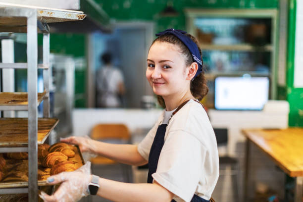 istock Young woman taking cooling rack with Fresh croissants 1439277063