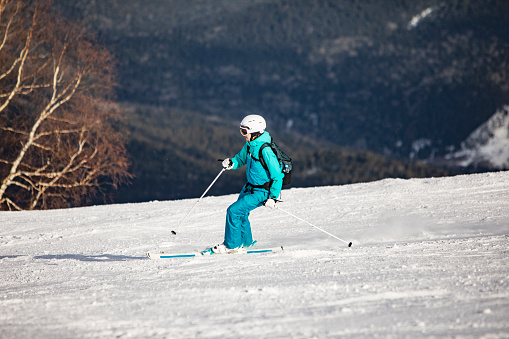 Young woman skiing in mountains at ski resort