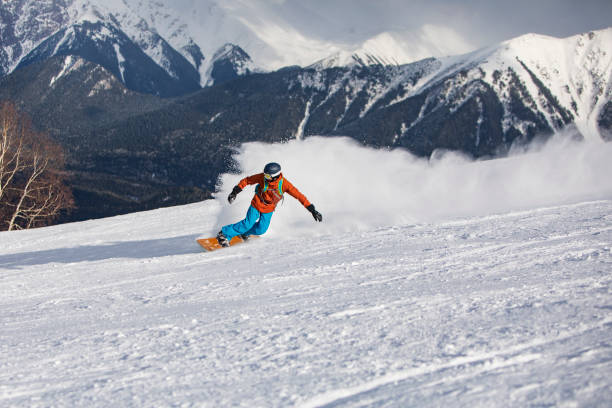 istock Young man snowboarding in mountains at ski resort 1439279208