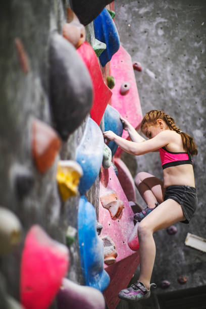 istock Little girl climbing on rock-climbing wall 1439280756