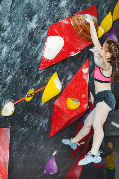 istock Little girl climbing on rock-climbing wall 1439280779