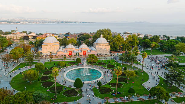 The Sultanahmet Square, also known as Hippodrome and surrounded by the famous Blue Mosque, Hagia Sophia Turkish and Islamic, one of the most famous tourist areas in Istanbul, as well as a popular meeting point. The area is very impressive tourist zone of the Sultanahmet neighborhood on the Historical Peninsula that leads to all historical sites around Sultanahmet. It is very well known place for all Istanbul visitors, where they mostly head on for first, on their first day of Istanbul visit. Once being a Byzantium hippodrome, the square itself hosts the famous historic places and sights that include; the Egyptian Obelisk, the Serpentine Column, the Colossus or the Column of Costantine Porphyrgenitus and the German Fountain. The Hippodrome of Constantinople (Greek: Ἱππόδρομος τῆς Κωνσταντινουπόλεως, romanized: Hippódromos tēs Kōnstantinoupóleōs, Latin: Circus Maximus Constantinopolitanus, Turkish: Hipodrom or Sultanahmet Meydanı) was a circus that was the sporting and social centre of Constantinople, capital of the Byzantine Empire. Today it is a square named Sultanahmet Meydanı (Sultan Ahmet Square) in the Turkish city of Istanbul, with a few fragments of the original structure surviving. The word hippodrome comes from the Greek hippos (ἵππος), horse, and dromos (δρόμος), path or way. For this reason, it is sometimes also called Atmeydanı ( vista aérea del estanque, piscina ornamental, plaza y lugares de estar, vista aérea de la gente que camina, vista aérea del parque y la gente, vista aérea de la plaza sultanahmet, santa sofía aérea, estambul aérea, santa sofía y mezquita azul, plaz