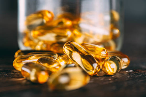 close-up omega 3 fish oil capsules - fish oil vitamin e cod liver oil nutritional supplement imagens e fotografias de stock