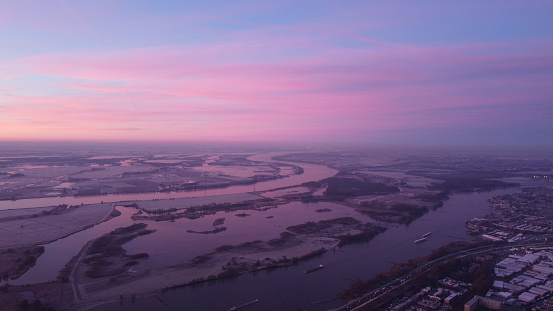 Pink sky above at river town Hardinxveld Giessendam at winter time in The Netherlands.