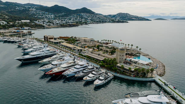 Yalikavak Marina is popular with yachties who come from all over to experience its superb facilities and one of the places to see in Yalikavak. It is just a short walk from the center of Yalikavak. Bodrum-Turkey vista aérea del club náutico. vista aérea de arriba hacia abajo de veleros atracados, yates y veleros anclados en el puerto deportivo de yalıkavak-bodrum, puerto deportivo con yates y barcos de lujo, vista aérea de barcos y yates, puerto deportivo de