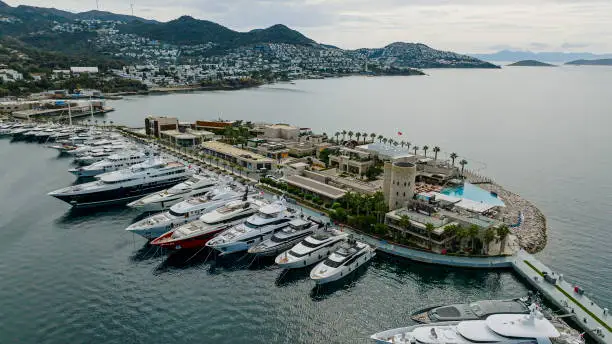 Photo of Aerial view of the yacht club. Aerial top-down view of docked sailboats,Yachts and sailboats anchored at the marina of Yalıkavak-Bodrum, Marina with luxury yachts and boats, aerial view of boats and yachts, Yalikavak marina