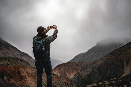 Making selfie standing in mountains at rainy weather