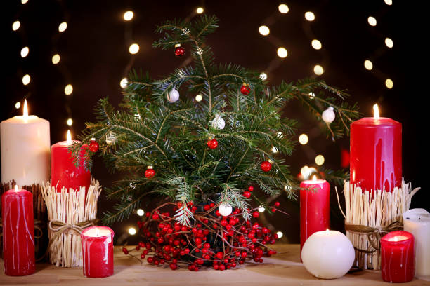 istock Festive christmas background candles green christmas tree on table warm backlight 1439294934