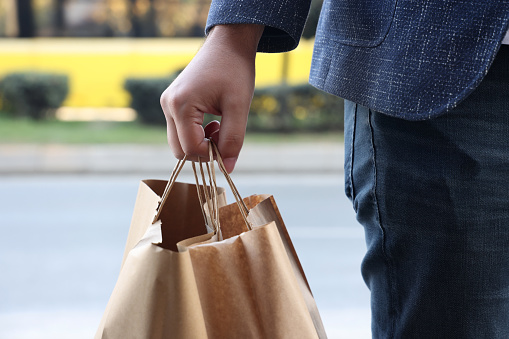 Man holding craft bag with take out food