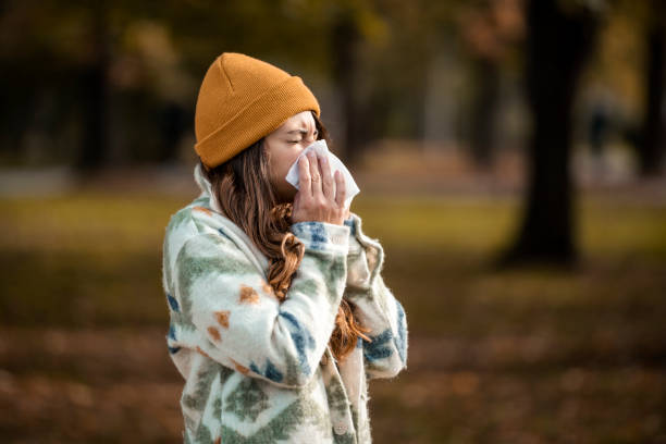 kobieta, kichanie w chusteczka do nosa na jesień - cold virus zdjęcia i obrazy z banku zdjęć