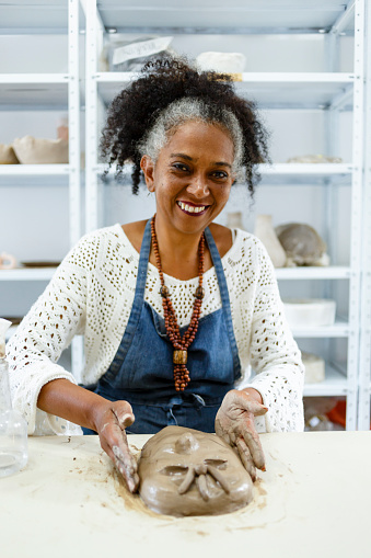 Portrait of black woman working on pottery