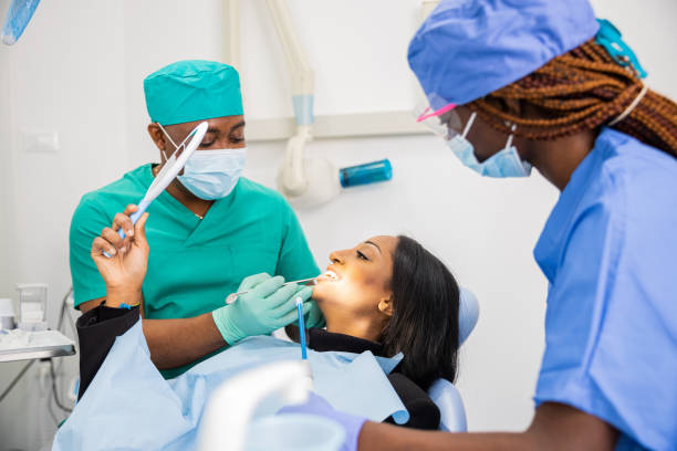 istock A patient looks at her teeth through the mirror, dental visit 1439310744