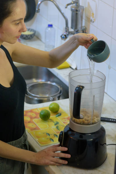istock Young girl inserting ingredients into a blender 1439314279