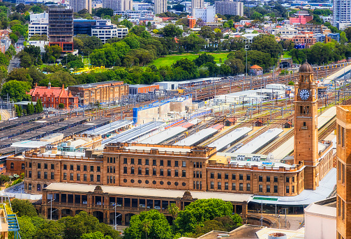 Close aerial view of Central railway station in city of Sydney CBD downtown with trains and platforms from elevation of high-rise tower.