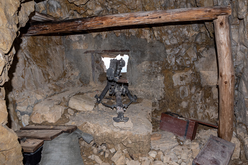 A loophole and an old machine gun in a tunnel of Mount Lagazuoi in the Dolomite Alps, built during the First World, Autonomous Pronvince of South Tirol