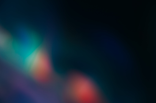 Neon light flare. Blur radiance. Bokeh glare leak. Defocused green red blue color glow beam reflection on dark black decorative abstract copy space background.