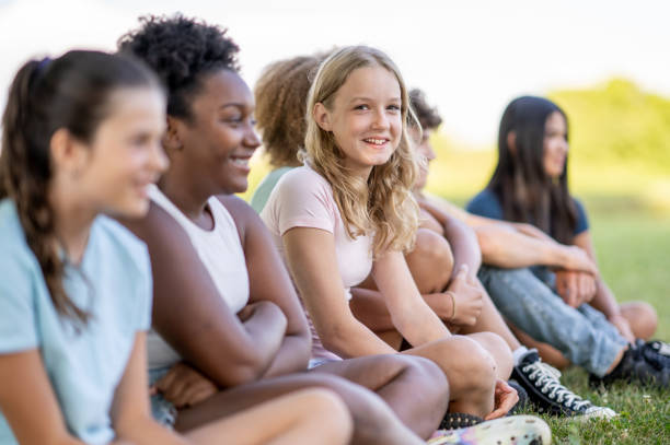 istock Kids sit next to each other on the grass 1439327190