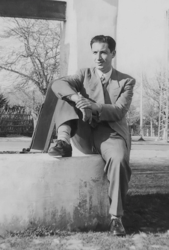 Black and white Image taken in the 40s: Elegant Young man wearing a suit sitting in a public park