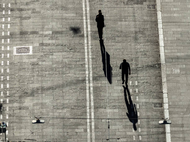 istock Silhouettes of pedestrians casting long shadows 1439334143