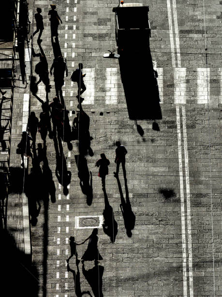 istock Silhouettes of pedestrians casting long shadows 1439334147