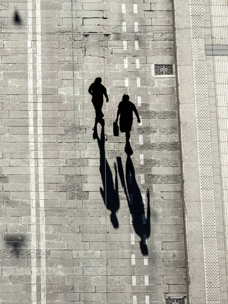 istock Silhouettes of pedestrians casting long shadows 1439334156