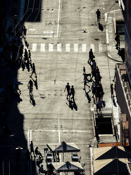 istock Silhouettes of pedestrians casting long shadows 1439334158
