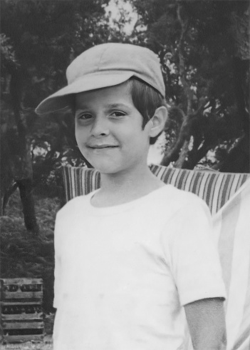 Black and white Image taken in the 60s; smiling boy wearing a cap looking at the camera