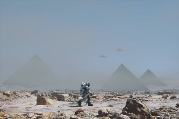 istock Astronaut walking on distant planet with mysterious pyramids 1439343910