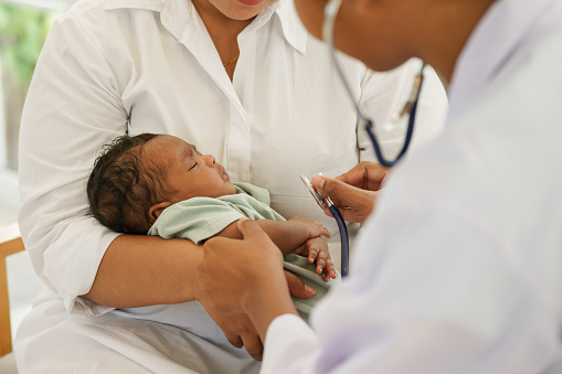 A newborn baby boy one-month-old mixed-race African-Thai,  visiting the doctor for checkup health with stethoscope at the clinic pediatric. concept consultation, check-up, nurse, healing infant.