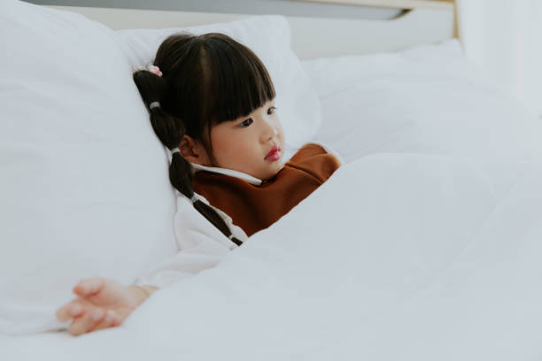 istock Little kid Asia girl lying on bed 1439355391