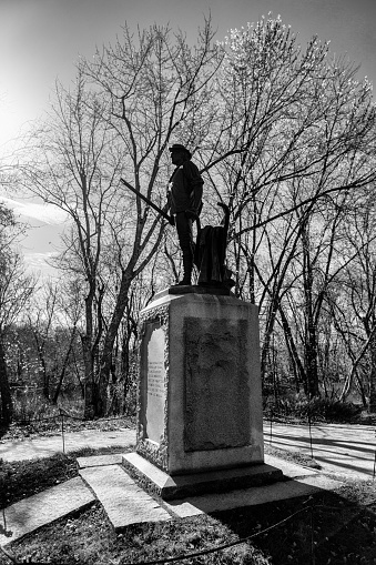 Concord, Massachusetts, USA - November 3, 2022: The Minute Man statue in black and white silhouette. The statue was unveiled and dedicated during the celebrations for the centennial of the Concord Fight on April 19, 1875. The statue was cast from melted down Civil War cannons. On April 19, 1775, the first day of the American Revolutionary War, provincial minutemen and militia companies engaged British Army troops at this location. The significance of the historic events inspired Ralph Waldo Emerson to refer to the moment as \