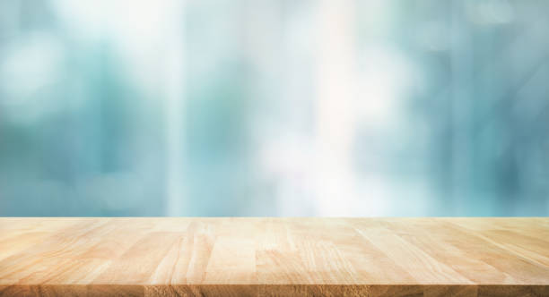 selektywne ustawianie ostrości. blat drewnianego stołu ze szkłem okiennym i tłem pejzażu miejskiego. - table zdjęcia i obrazy z banku zdjęć