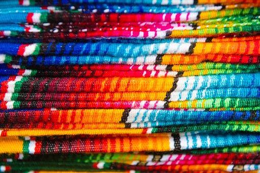 Closeup image of classical colorful Peruvian and Bolvian clothes and handicraft at the indigenous market in Otavalo. Ecuador 2015.