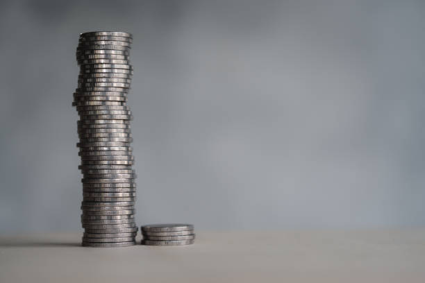 istock Coins arranged vertically on wood plank background , Saving and growing business concept, selective focus. 1439375883