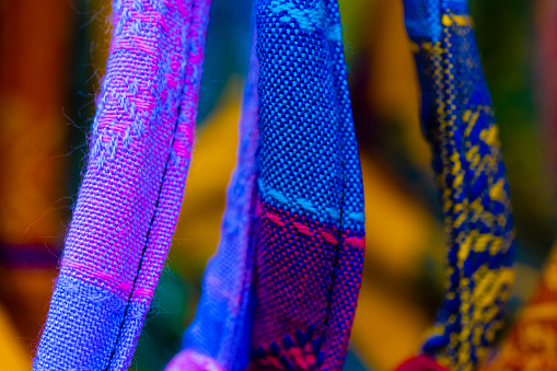 This is an abstract close up photograph of the handles of several colorful fabric purses for sale in Playa Del Carmen, Mexico