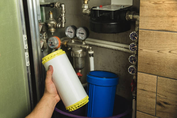 istock Replacing the filter element in the home water purification system close-up. View through the open hatch in the bathroom 1439386667