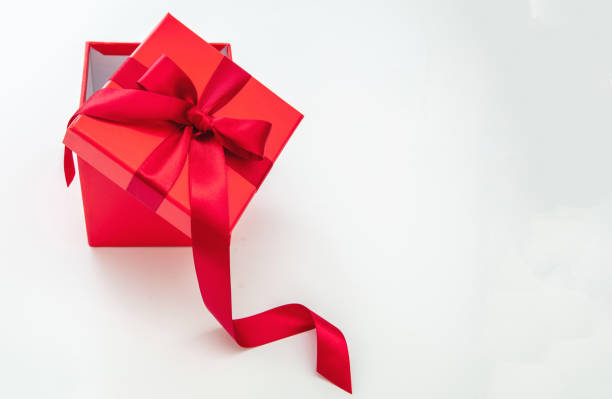 istock Red gift box with red passion ribbon isolated cutout on white background, overhead 1439388790