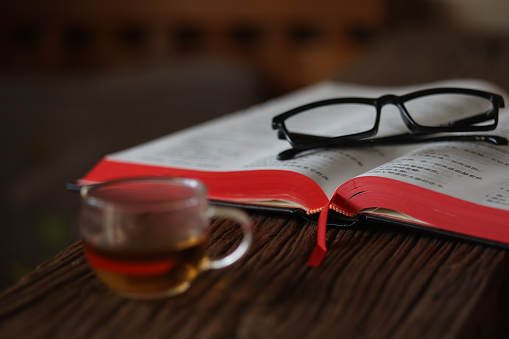 Open Holy Bible on a old brown wooden table