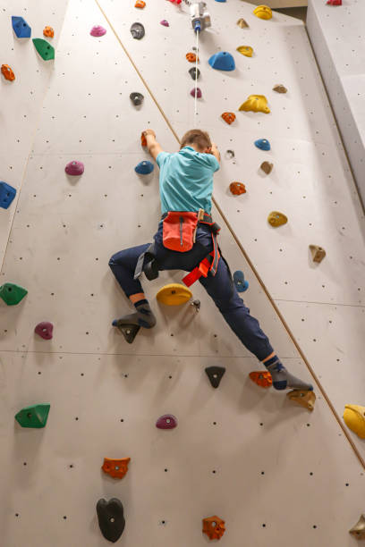 istock Young boy is climbing with top rope on indoor climbing wall 1439392198