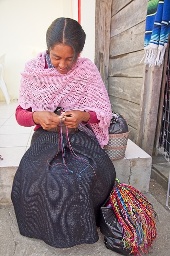 San Juan Chamula, Mexico – April 20, 2019: Woman handcrafting colourful bracelets in San Juan Chamula, Mexico