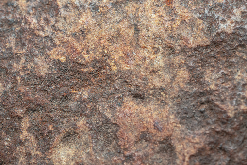 Textured surface of the rock with brown tint background