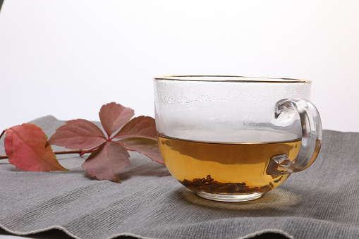 Cup of tea with mint and lemon on a white background