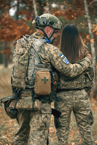 Ukrainian soldiers man and woman dressed military uniform at front line.