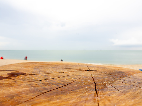 Empty wooden log with blur beach on background, can be used for product placement.