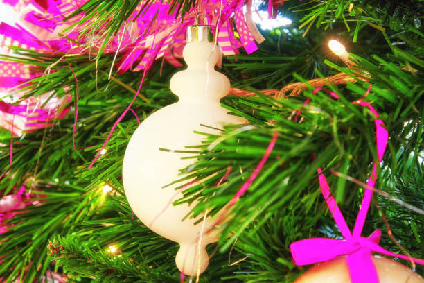 Bright white bauble toy on the evergreen Christmas tree branch. New year theme and backgrounds