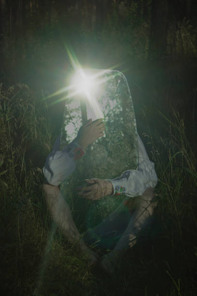 istock large oval mirror is held with hands and feet, the sun is reflected in the mirror with rays against the background of nature 1439411917