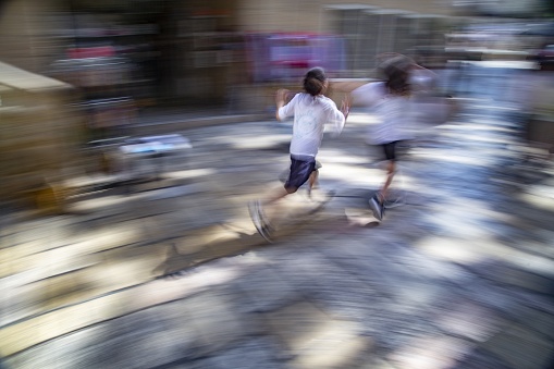 A long exposure high angle shot of children running in the streets