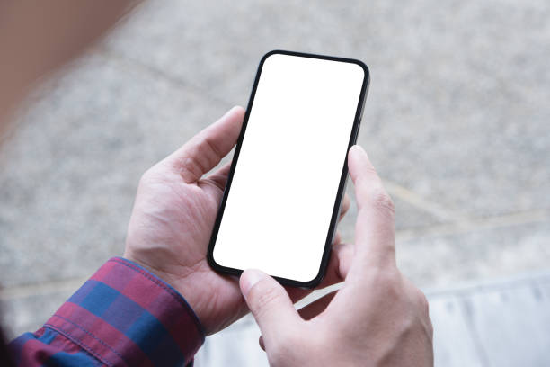 istock Cell phone blank white screen mockup. Man hand holding using mobile phone at coffee shop. empty space template for advertise. People contact business marketing 1439412816