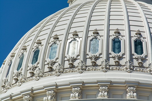 The dome of The United States Capitol under the sunlight and a blue sky in Washington DC