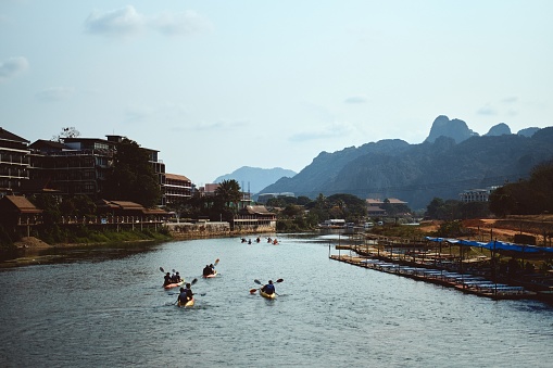 The Nam Xong River surrounded by buildings and rocks under the sunlight in Vang Vieng in Laos